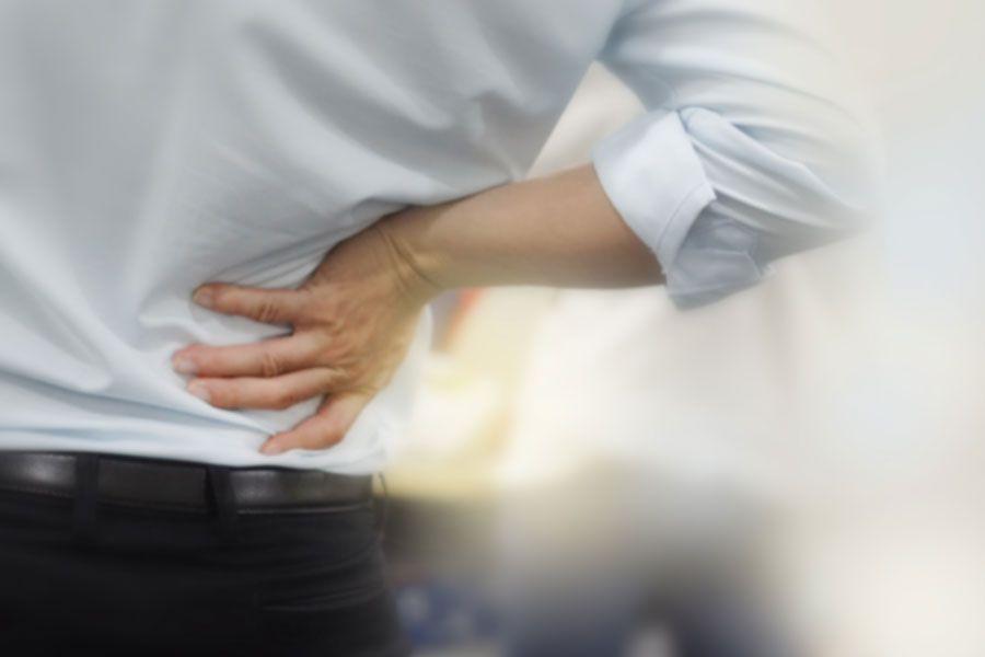 A person holding his back in pain.
