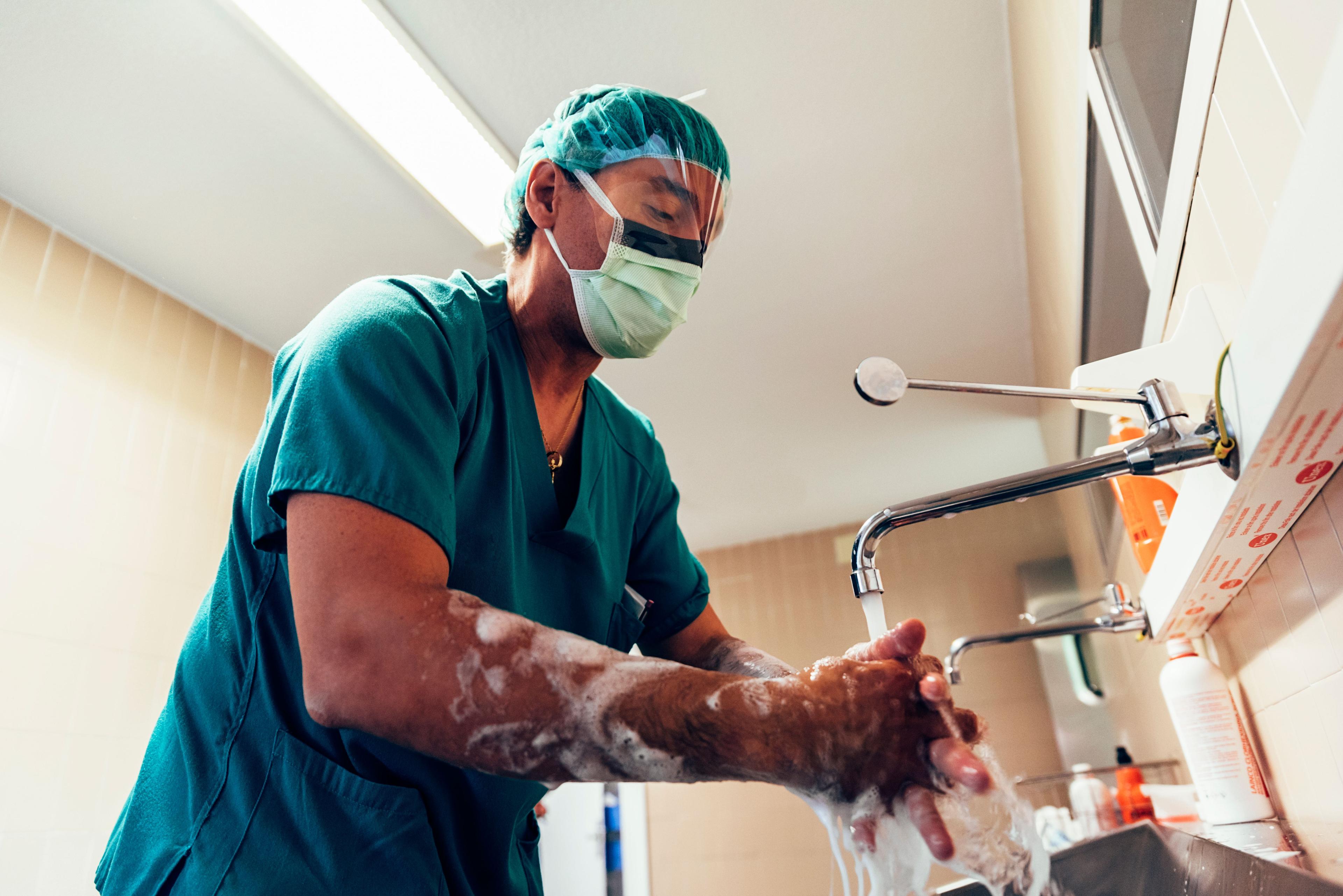 Surgeon washing hands meticulously as part of the surgical process.