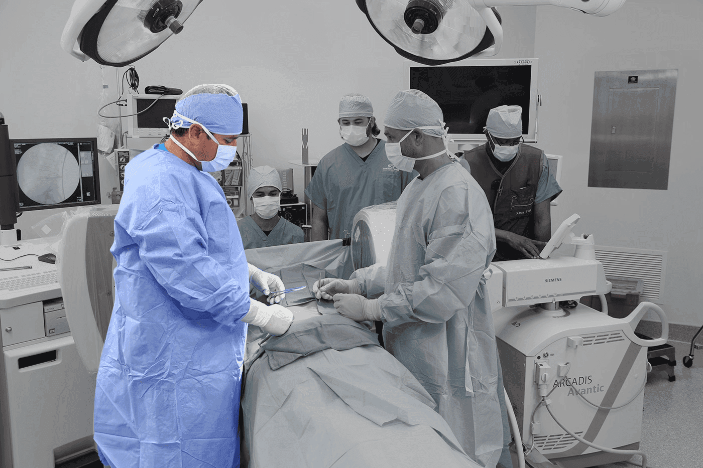 Team of surgeons performing an operation in a well-equipped surgical room.