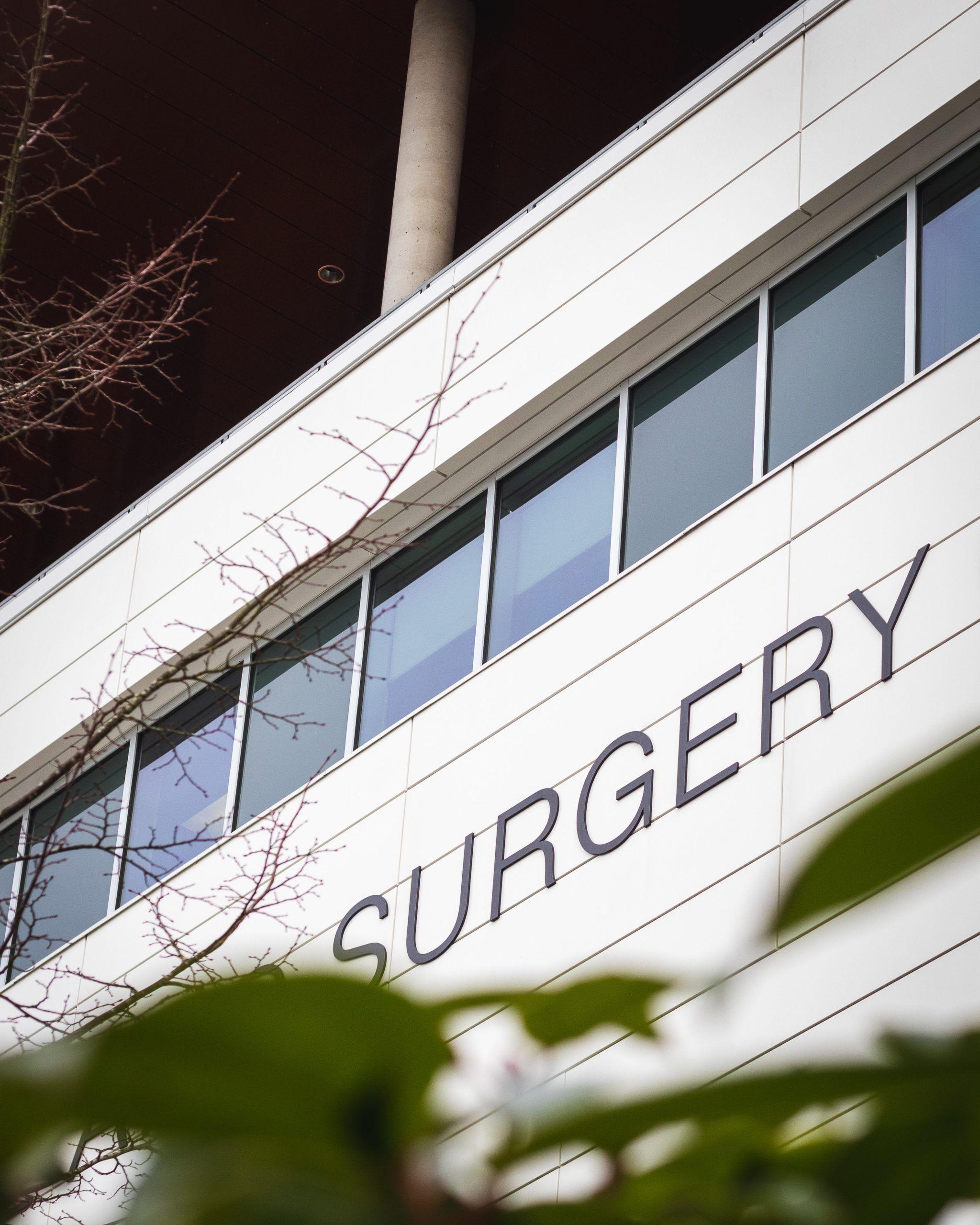 Exterior of a modern building with the word "SURGERY" displayed prominently.