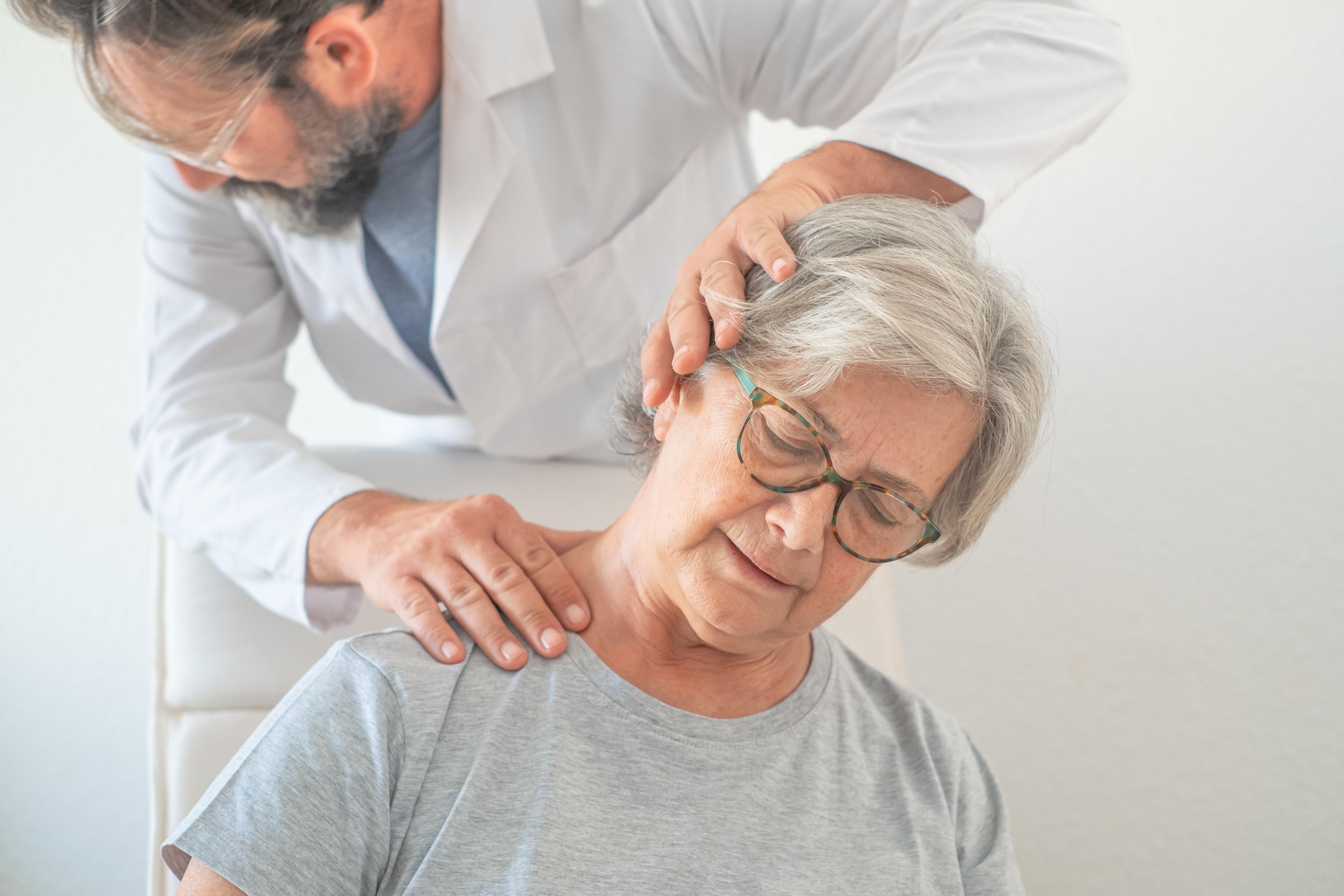 Spine surgeon examining patient with neck pain