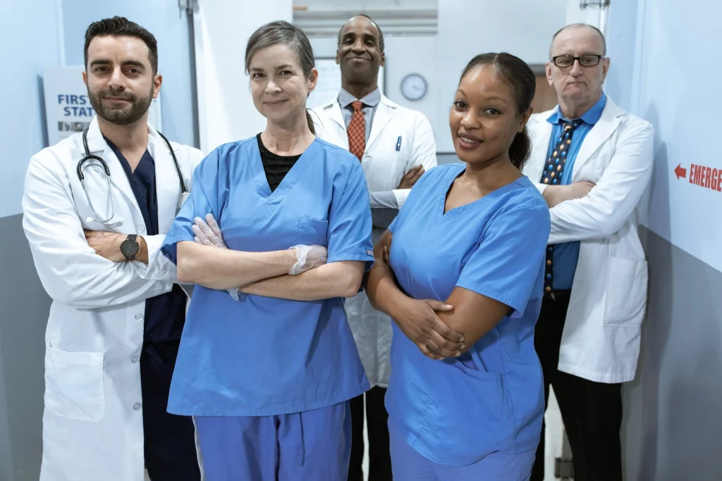 Four diverse medical professionals posing confidently in an emergency room.