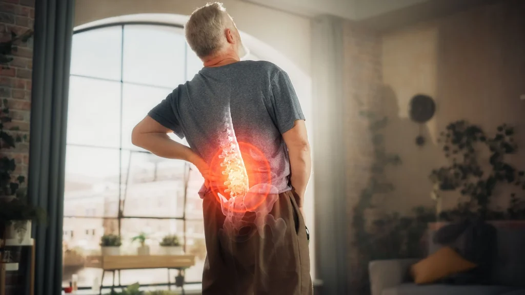 Man with visualized back pain due to spine arthritis in a living room.