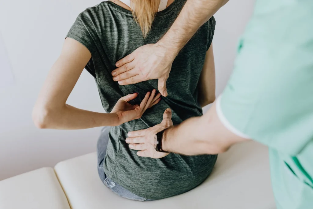 A picture of a lady with chronic back pain being diagnosed.