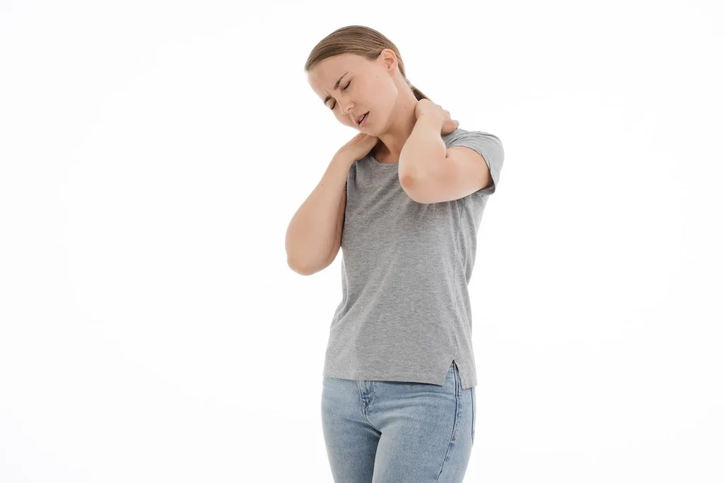 Woman massaging her neck in pain .
