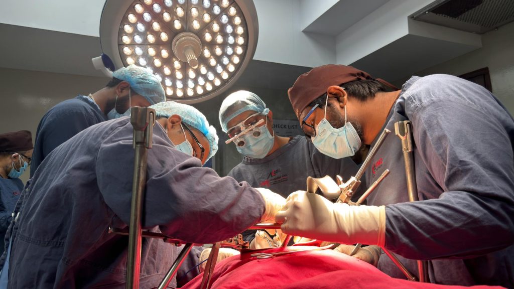 Surgical team performing an operation under a bright operating room light.
