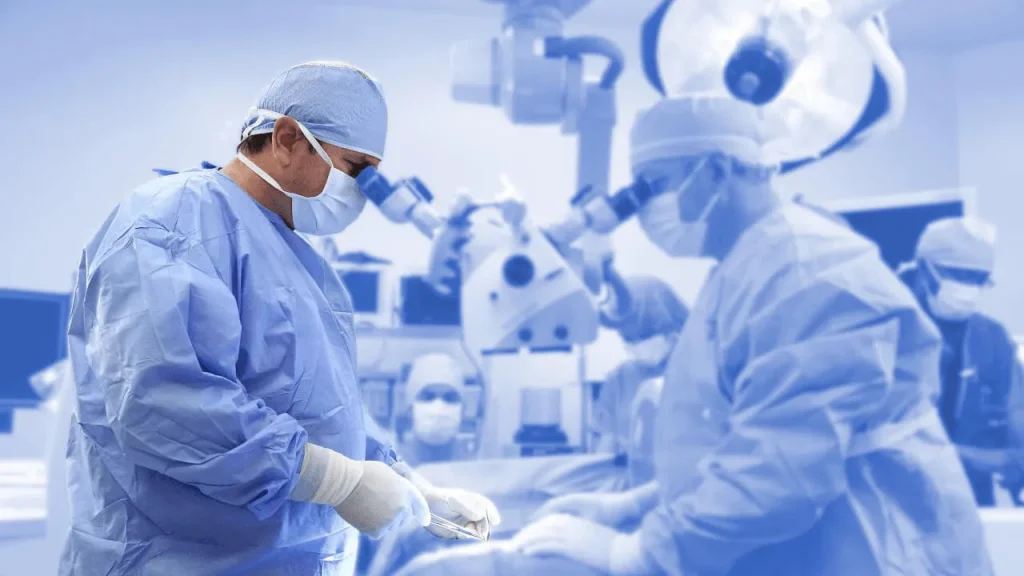 Surgeons in blue scrubs operating in a surgical room with modern equipment.