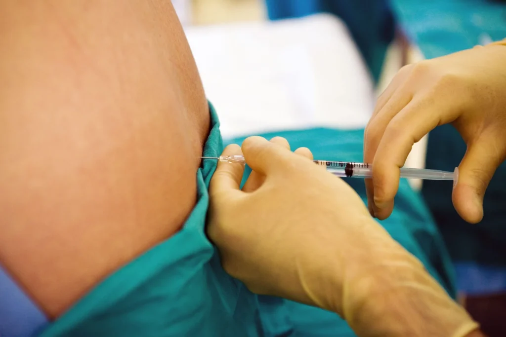 Healthcare professional administering facet block injection for pain management.