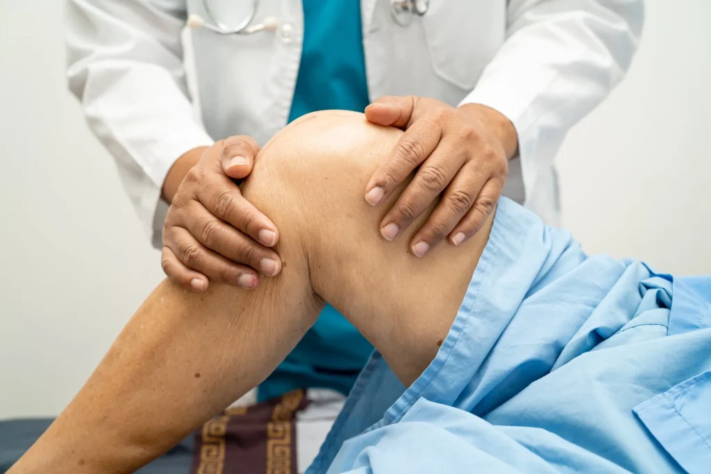 A doctor examines a patient's knee, potentially related to herniated disc symptoms.