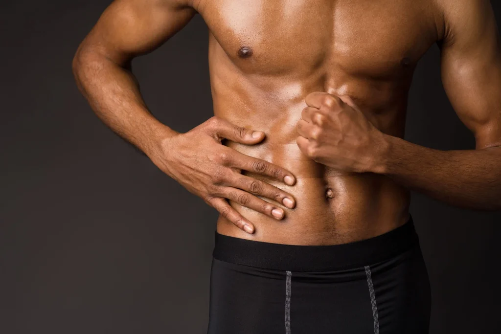 Man clutching his lower back, illustrating pain from L5-S1 herniation, related to symptom management of lower back pain.