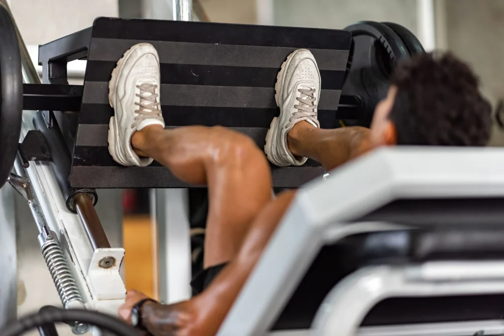 A person uses a leg press machine, an activity to be cautious with if experiencing a herniated disc.