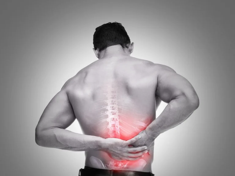 A man holding his lower back, with a highlighted spine and red area indicating pain.