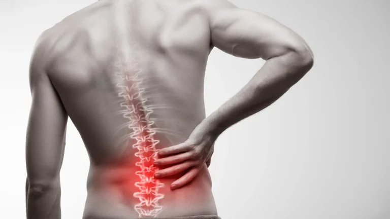 Person holding their lower back, with highlighted spine and red area indicating pain.