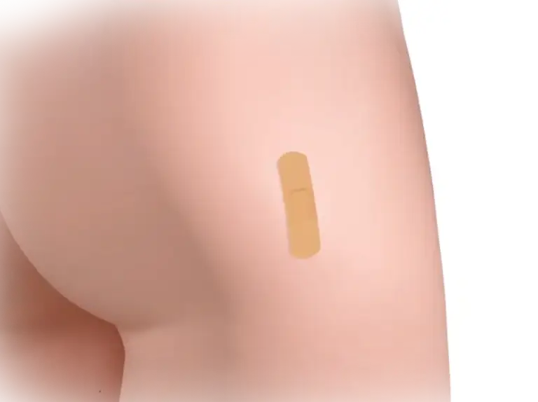 A close-up of a bare arm with a small bandage applied.