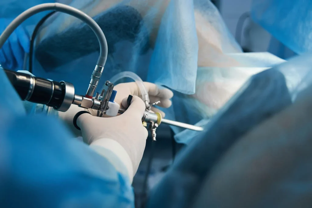 Surgeon performing a minimally invasive procedure using laparoscopic instruments.