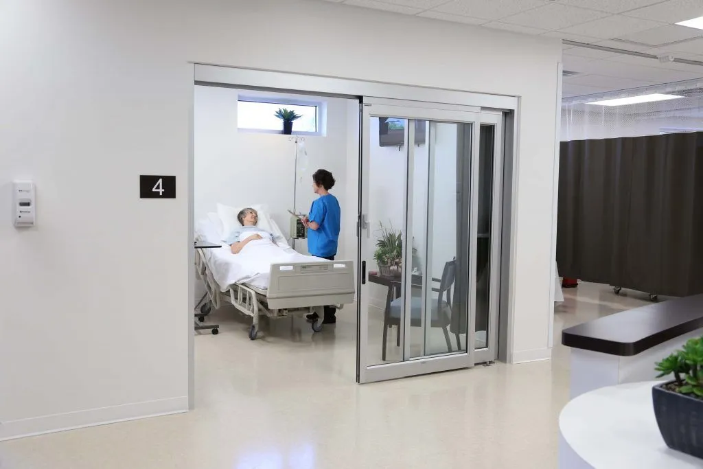 A healthcare professional attends to a patient in a hospital room labeled "4.