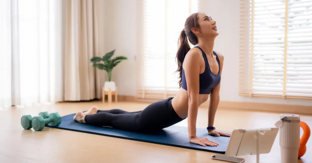 Woman performing a prone press-up stretch on a yoga mat to help relieve L5-S1 lower back pain and improve spinal extension.