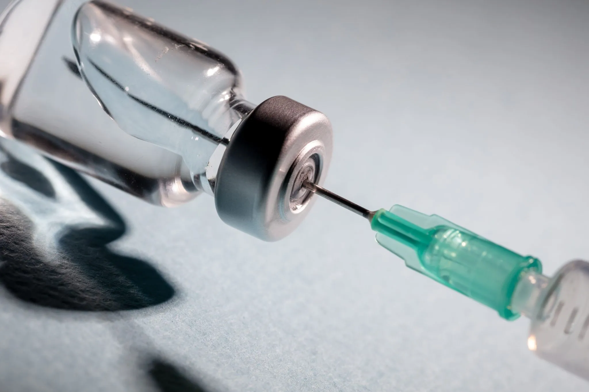 A close-up image of a syringe drawing medication from a vial, symbolizing medical treatments such as epidural steroid injections.