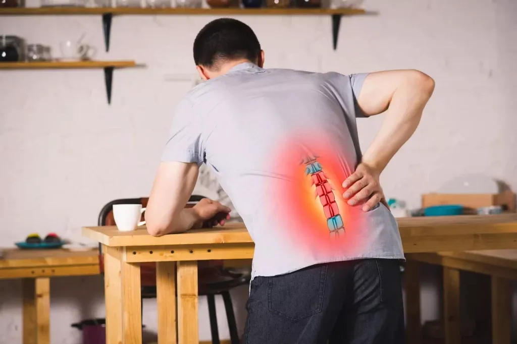 Man experiencing lower back pain with a visible red glow due to a herniated disc.