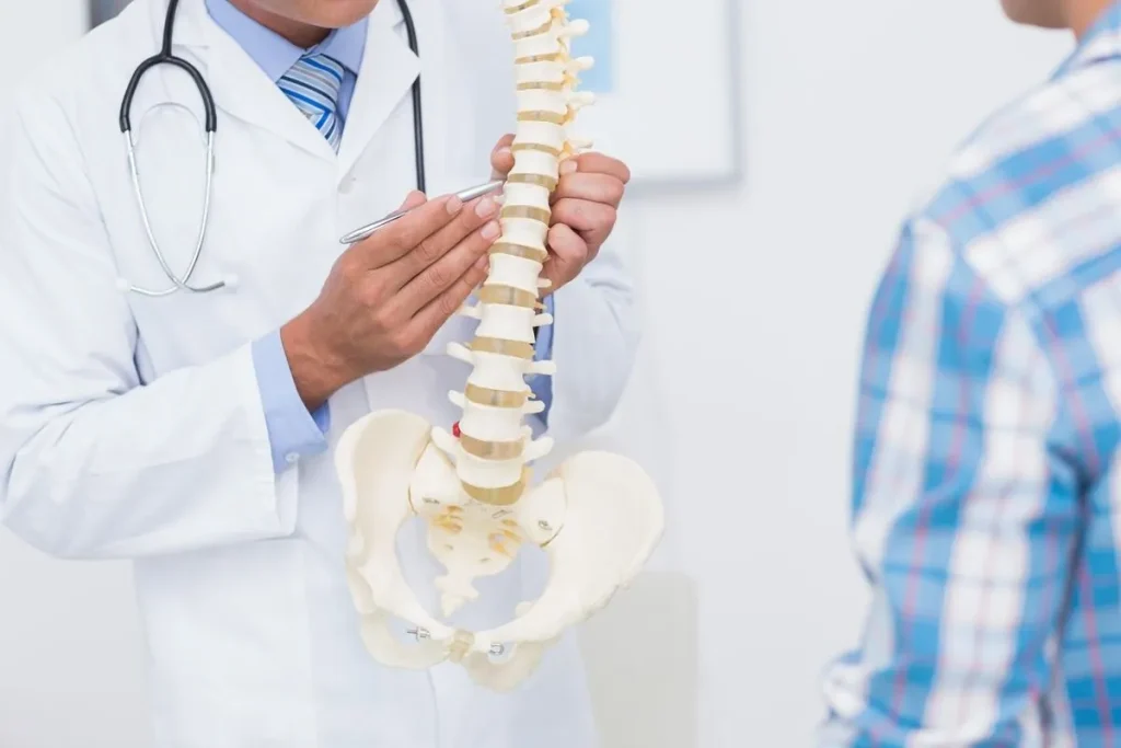 Doctor explaining spine model to a patient.