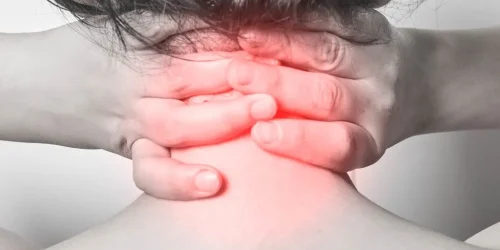 person experiencing neck pain, clutching the back of their neck with both hands, highlighting the area with visible red inflammation.