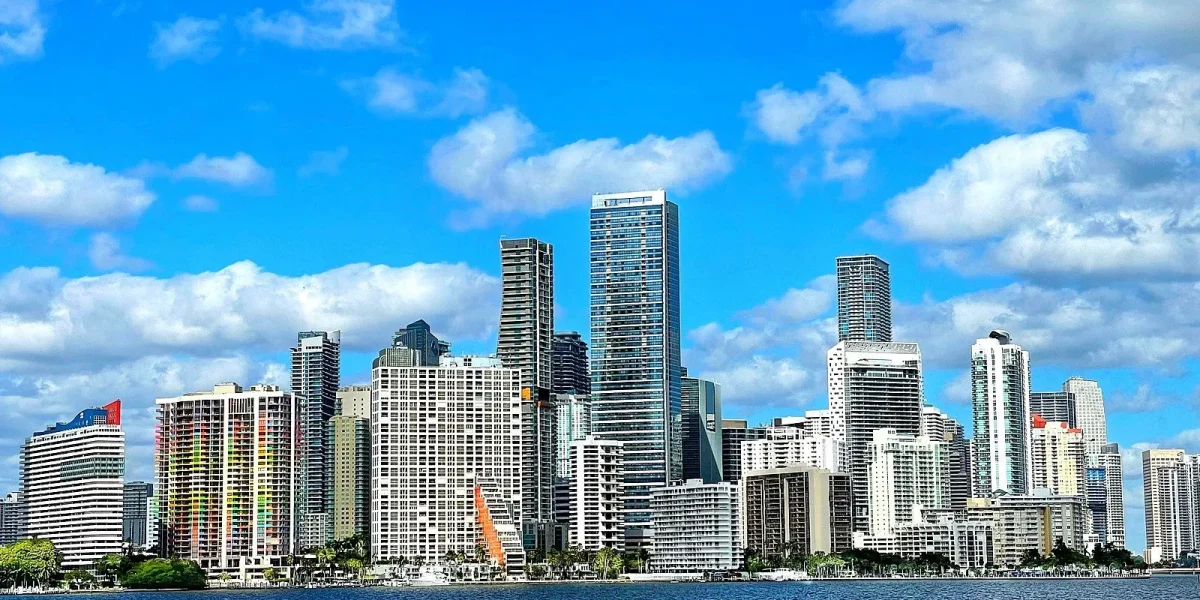 Miami skyline view from water, showing modern buildings under blue sky.