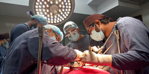 Surgical team performing an operation under a bright operating room light.