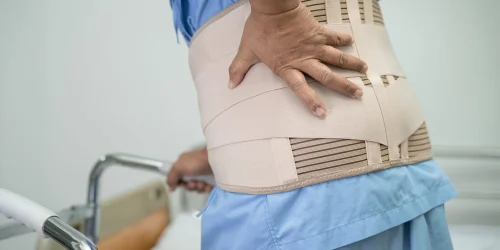 Person wearing a back brace, illustrating chronic pain
