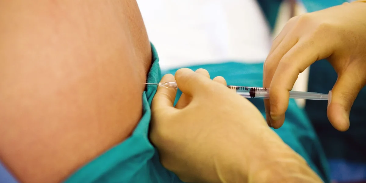 Healthcare professional administering facet block injection for pain management.