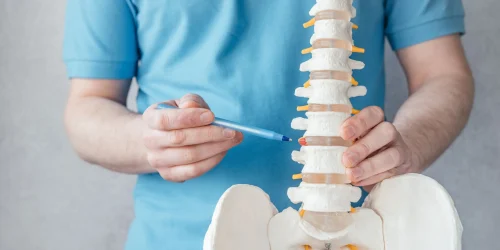 Surgeon indicating areas of spine where lumbar fusion surgery takes place