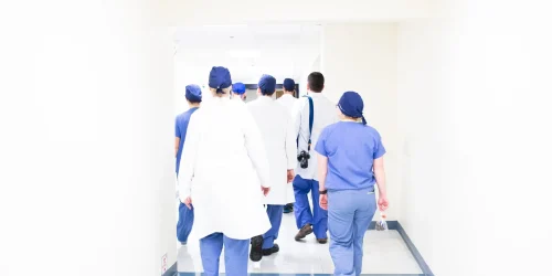 Group of medical staff in scrubs walking down a hospital corridor.