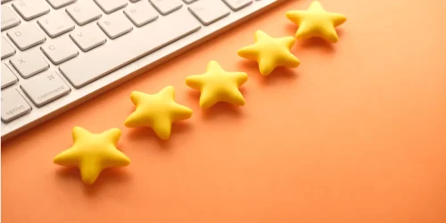 A picture of laptop with 5 stars lying next to it in a straight line mostly trying to portray the meaning of reviews.