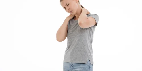 Woman massaging her neck in pain .
